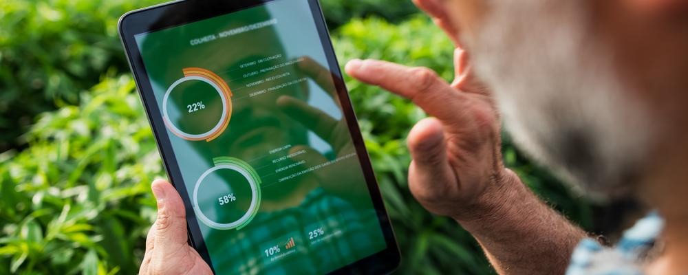 Man looking at agricultural data on his smartphone in an agricultural field